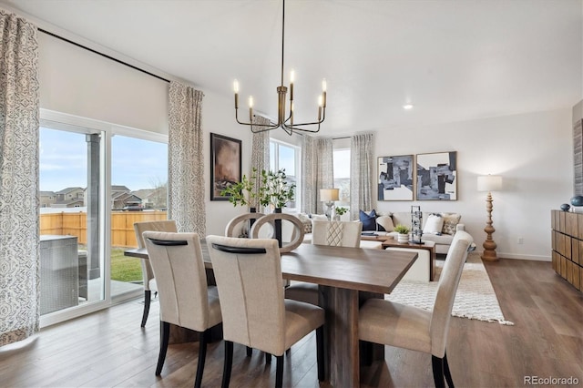 dining space featuring a notable chandelier and light wood-type flooring