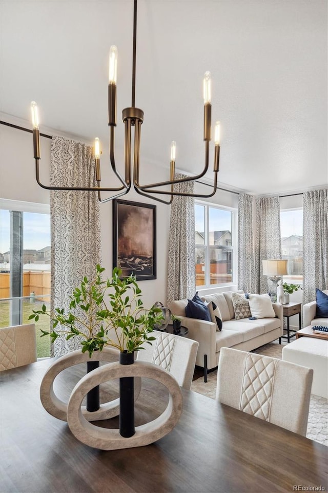 dining area with wood-type flooring, plenty of natural light, and a chandelier