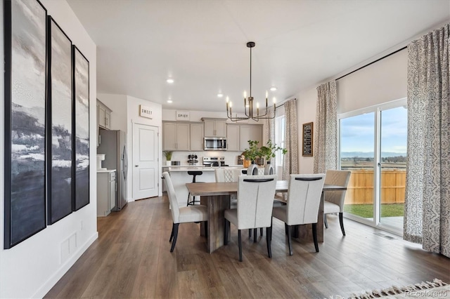 dining space with dark hardwood / wood-style floors and a chandelier