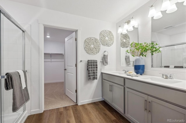 bathroom featuring wood-type flooring, an enclosed shower, and vanity