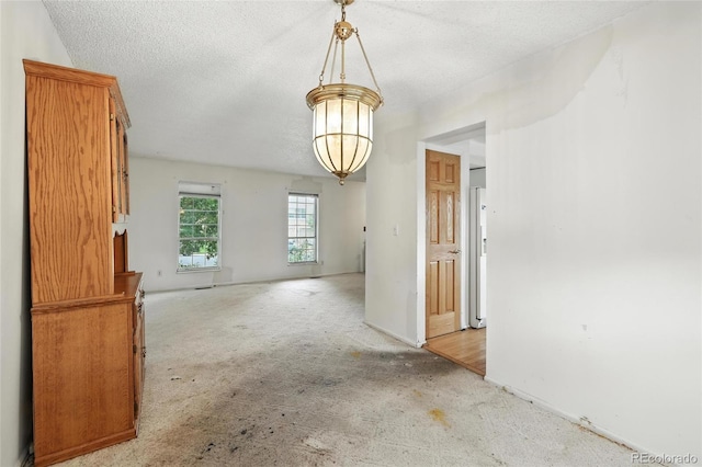 2527 S Ouray Way, Aurora, CO 80013 - unfurnished dining area with light colored carpet, a textured ceiling, and a chandelier