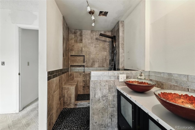 2527 S Ouray Way, Aurora, CO 80013 - bathroom featuring walk in shower, tile walls, and double vanity