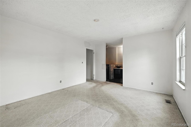 2527 S Ouray Way, Aurora, CO 80013 - unfurnished living room with a textured ceiling and light colored carpet