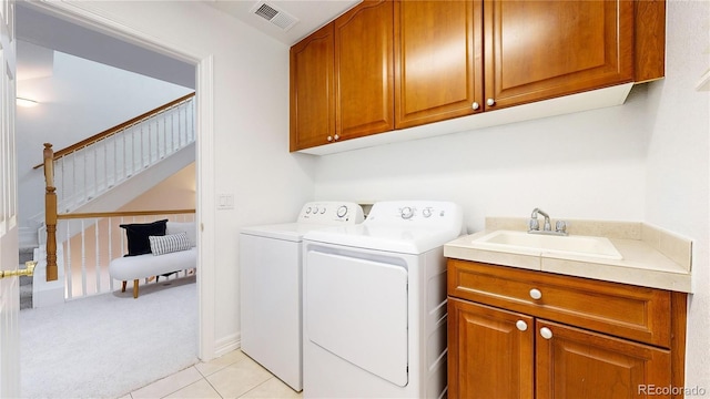 203 S Jackson St, Denver, CO 80209 - laundry area featuring cabinet space, washing machine and dryer, light carpet, and light tile patterned floors