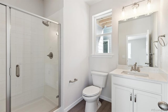 bathroom with a shower with door, vanity, hardwood / wood-style flooring, and toilet