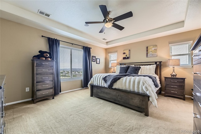 16059 E Grass River Pl, Parker, CO 80134 - bedroom featuring light carpet, a tray ceiling, and a ceiling fan