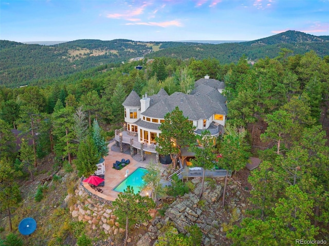 birds eye view of property featuring a view of trees and a mountain view