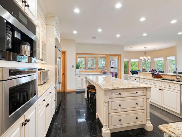 kitchen with a kitchen island, sink, a chandelier, and dark tile patterned flooring