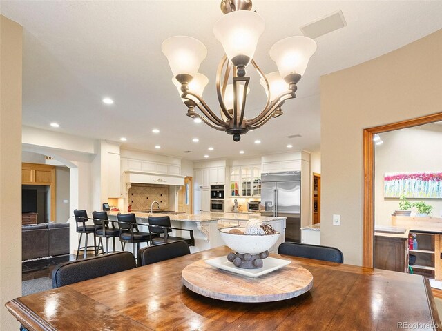 dining space with sink and a chandelier