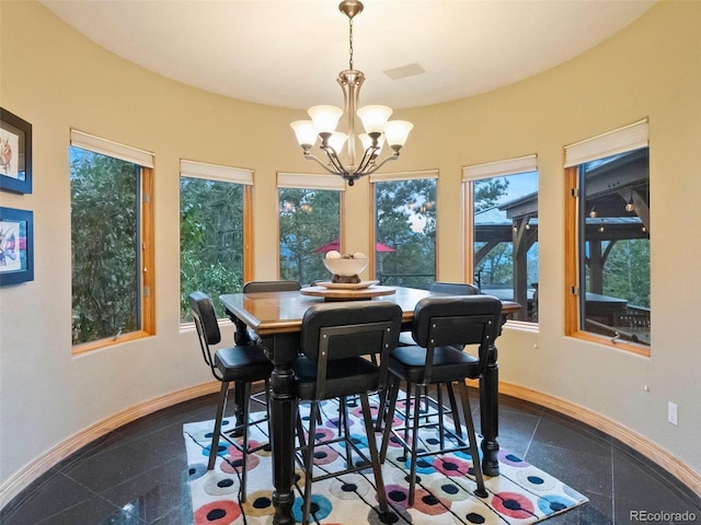 dining area featuring baseboards, a notable chandelier, and granite finish floor