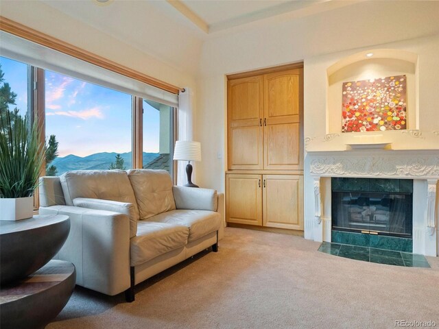 carpeted living room featuring a tiled fireplace and a mountain view