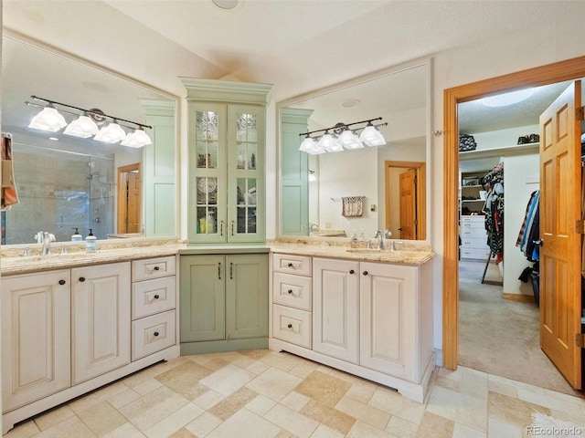 bathroom featuring a stall shower, vanity, and a walk in closet