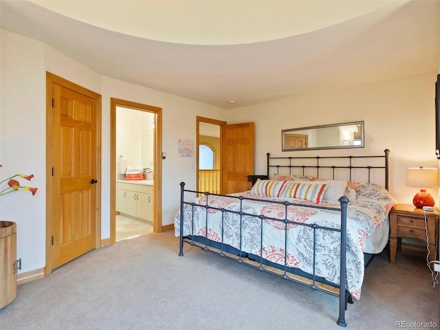 carpeted bedroom featuring baseboards and ensuite bath