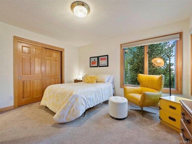 carpeted bedroom featuring a textured ceiling and a closet