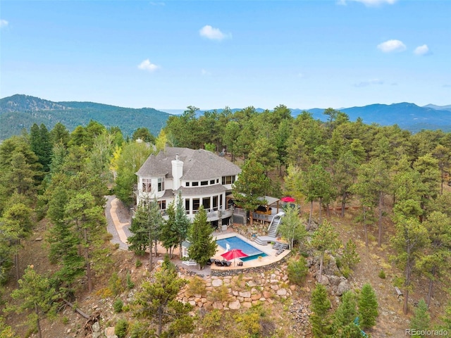 drone / aerial view with a wooded view and a mountain view