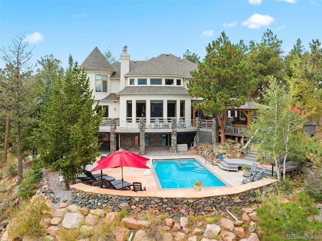 rear view of house with an outdoor pool, stairway, a deck, and a patio area