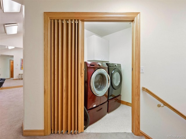 laundry room featuring cabinets, independent washer and dryer, and light colored carpet