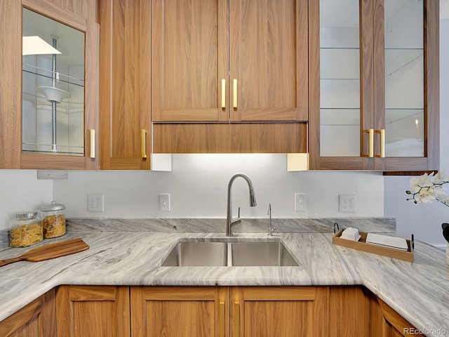 kitchen featuring light stone countertops and sink