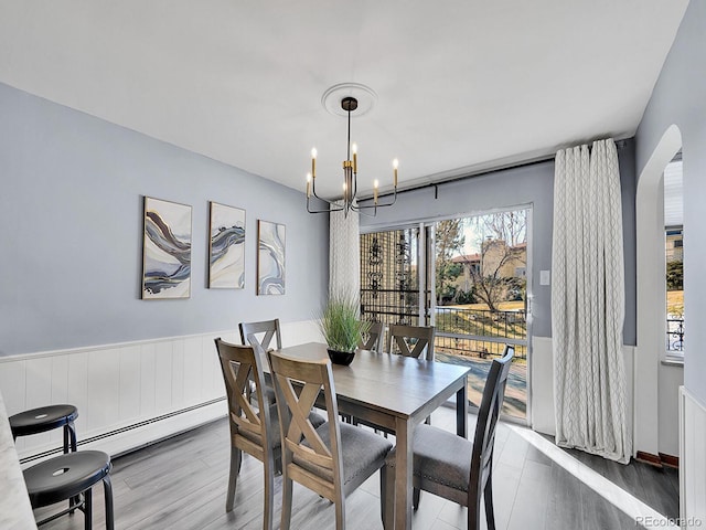 dining space featuring hardwood / wood-style floors, a chandelier, and baseboard heating