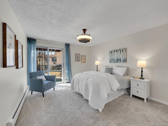 carpeted bedroom featuring access to exterior, a textured ceiling, and a baseboard heating unit