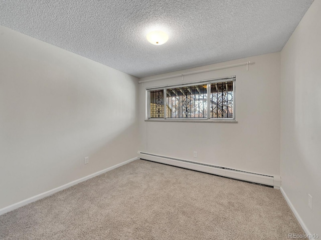 carpeted empty room with a baseboard radiator and a textured ceiling