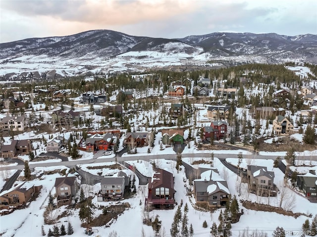 snowy aerial view with a residential view and a mountain view