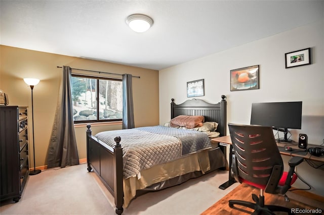 bedroom featuring light colored carpet and baseboards