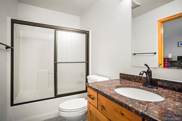 full bathroom with bath / shower combo with glass door, toilet, and vanity