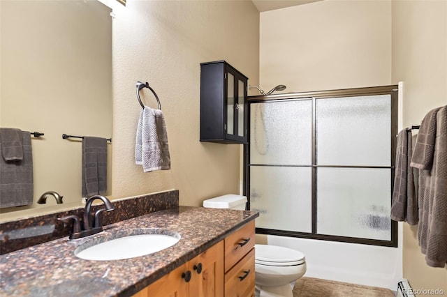 full bath with vanity, toilet, baseboard heating, and enclosed tub / shower combo