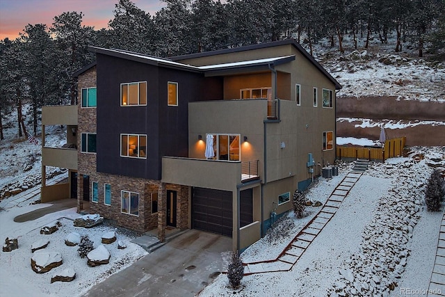 exterior space featuring central AC unit, a garage, and a balcony