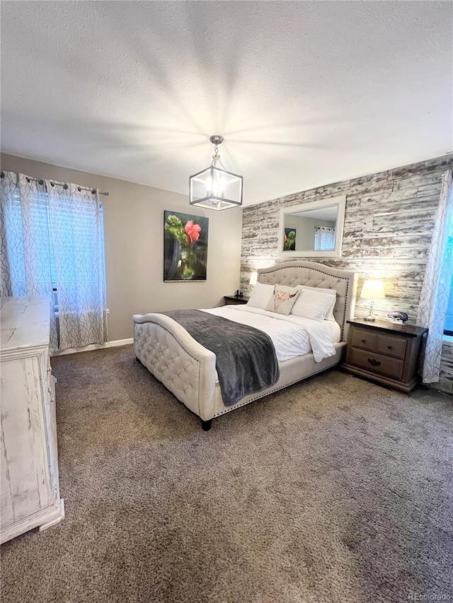 bedroom featuring carpet flooring, a textured ceiling, and a chandelier