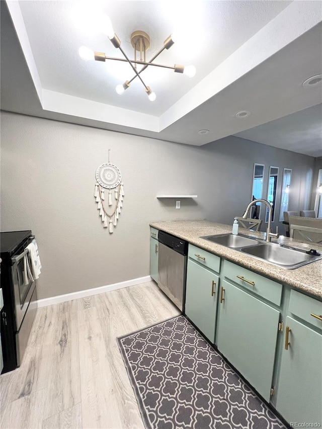 kitchen featuring stainless steel appliances, a tray ceiling, light hardwood / wood-style flooring, sink, and a chandelier