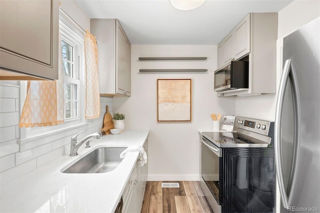 1805 W 51st Ave, Denver, CO 80221 - kitchen with wood finished floors, a sink, stainless steel appliances, baseboards, and light countertops