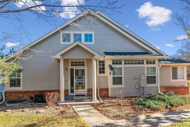 bungalow-style house featuring brick siding and a shingled roof