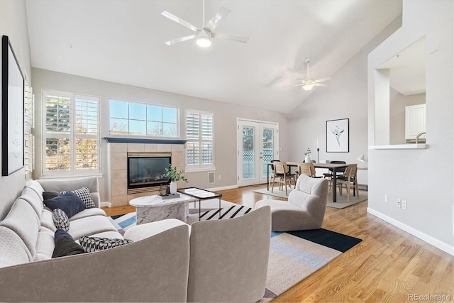 living room featuring a wealth of natural light, ceiling fan, and light wood-type flooring