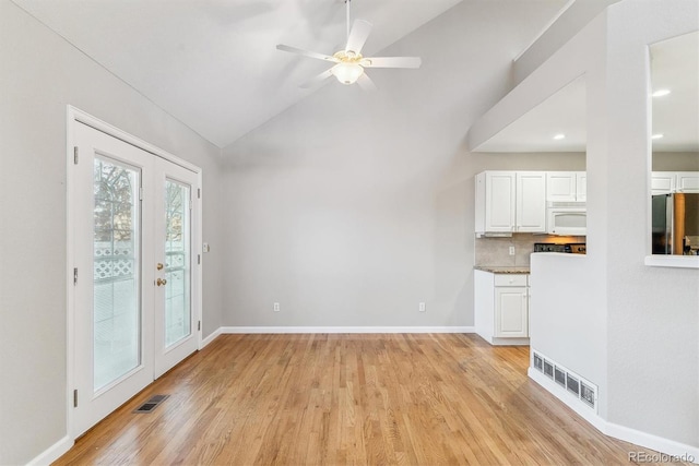 unfurnished living room with ceiling fan, french doors, light hardwood / wood-style floors, and lofted ceiling