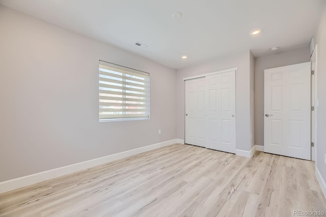 unfurnished bedroom with a closet and light hardwood / wood-style flooring