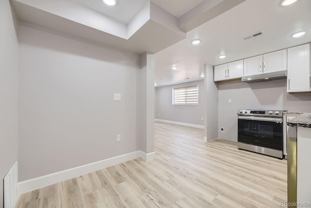 kitchen featuring dark stone countertops, light hardwood / wood-style flooring, white cabinets, and stainless steel electric range oven