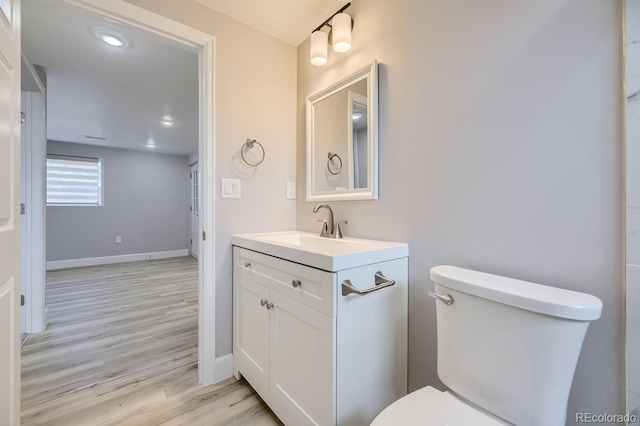 bathroom featuring vanity, hardwood / wood-style flooring, and toilet