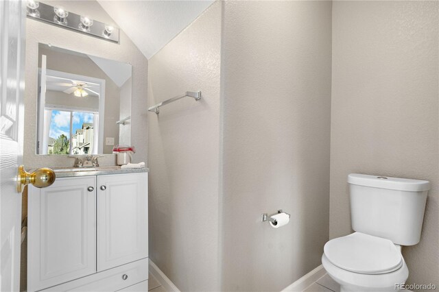 bathroom with toilet, baseboards, vaulted ceiling, and vanity