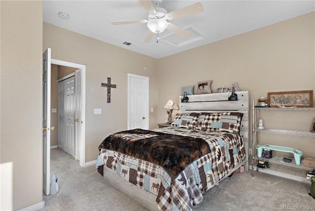 carpeted bedroom with attic access, visible vents, baseboards, and a ceiling fan