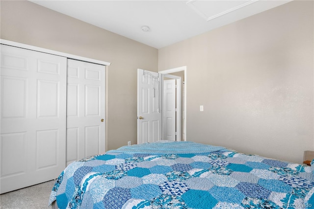 carpeted bedroom with attic access and a closet