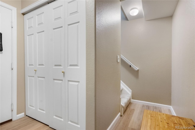 hall with stairs, baseboards, and wood finished floors