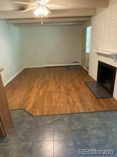 unfurnished living room featuring dark hardwood / wood-style flooring, ceiling fan, a fireplace, and beamed ceiling