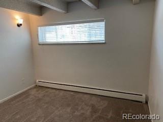 empty room featuring carpet floors and a baseboard radiator