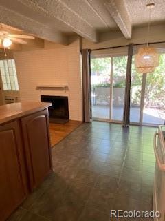 unfurnished living room featuring tile patterned flooring, beamed ceiling, and ceiling fan