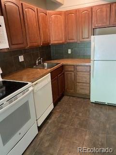 kitchen with sink, white appliances, and decorative backsplash