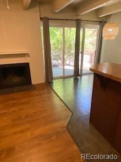 unfurnished living room featuring beamed ceiling and hardwood / wood-style floors