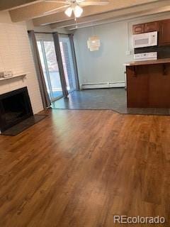 unfurnished living room featuring a fireplace, a baseboard radiator, dark hardwood / wood-style floors, and ceiling fan