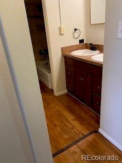 bathroom with vanity, wood-type flooring, and shower / tub combination